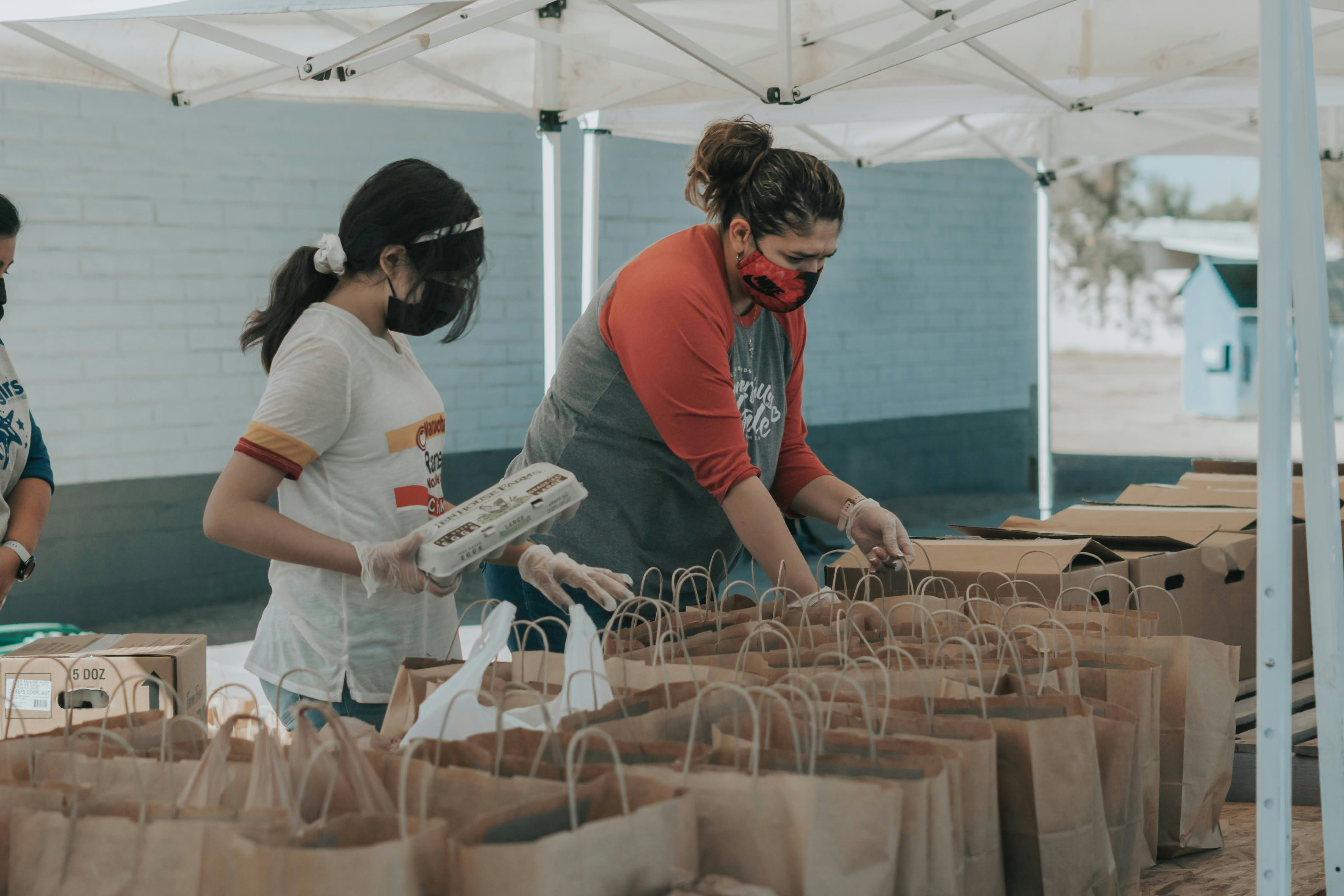 Volunteers organizing food donations in a food bank warehouse